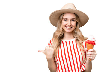 Young English woman with a cornet ice cream over isolated background pointing to the side to...