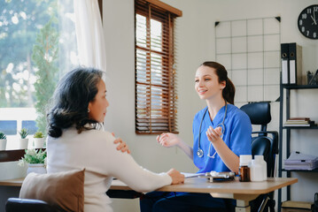 Asian Doctor and patient discussing something while sitting at the table . Medicine and health care concept. .