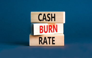 Cash burn rate symbol. Concept words Cash burn rate on wooden blocks on a beautiful grey table grey background. Business cash burn rate concept. Copy space.