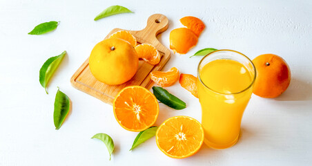 Freshly squeezed orange juice and orange fruit cut in half