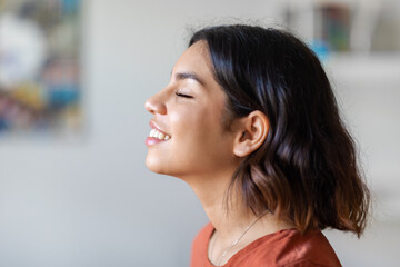 Profile Shot Of Delighted Young Arab Woman Smiling With Eyes Closed