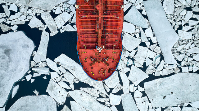 An orange-coloured tanker passes through thick ice in search of an icebreaker that will guide tankers through the arctic ice