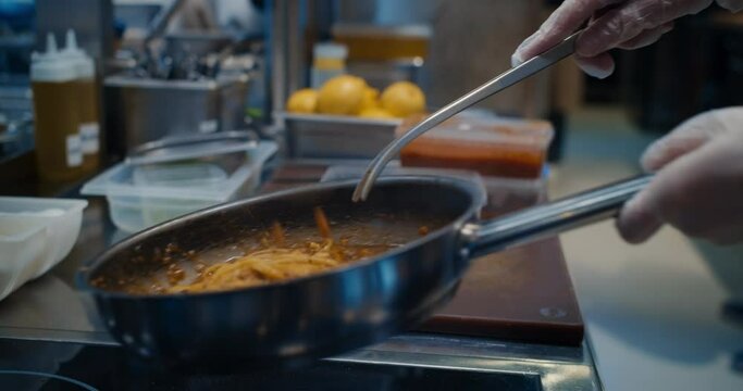Chef cooking bolognese fresh pasta with tomato sause, man making traditional italian dinner