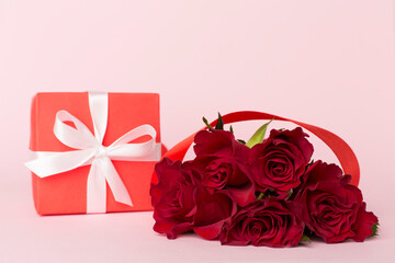 Valentines day red roses with gift on color table