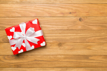 Gift box with hearts on wooden background, top view