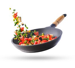 Fresh chopped vegetables mix flying in a pan, isolated on white background