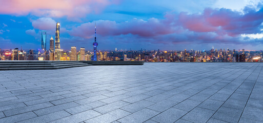 Empty square floor and city skyline with modern building at night in Shanghai, China.