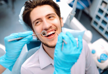 Man at the dentist's chair during a dental procedure. Overview of dental caries prevention.  Healthy teeth and medicine concept. 