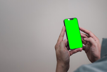 mock up picture of hand using mobile phone with green screen empty space