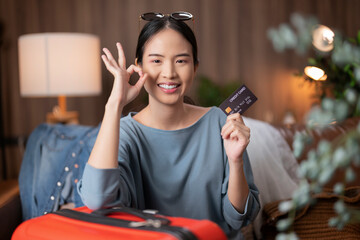 Asian traveller Tourist woman casual cloth in hotel room making credit card reservation for flight...