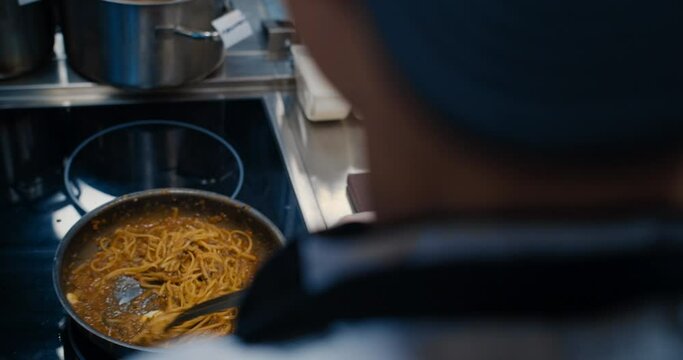 Chef cooking bolognese fresh pasta with tomato sause, man making traditional italian dinner