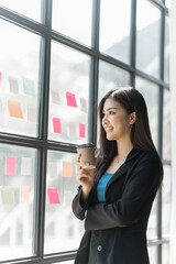 Fototapeta premium Pretty asia business woman bookkeeper brainstorming and working in modern office workplace with sticky notes or post it at windows.
