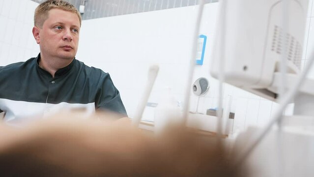doctor does an ultrasound of the veins on the patient's legs. A phlebologist checks the veins on a woman's legs with an ultrasound machine in a modern clinic.