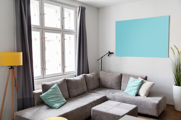 Cozy living room interior with comfortable grey sofa and big window