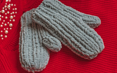 Fototapeta na wymiar Warm grey knitted gloves. Fashionable collection of accessories for women. Detail of wardrobe