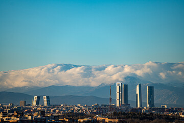 Fototapeta na wymiar City of Madrid with the towers of Castellana street and the Navacerrada mountain with snow.