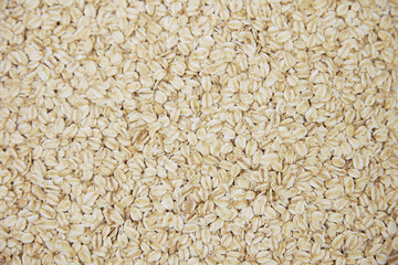 Rolled oat, oat flakes background or texture. Close up, directly above.