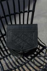 small black women's leather bag with a carved pattern. selective focus