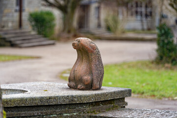 Stone sculpture of bear at fountain at school yard at City of Zürich district Schwamendingen on a gray and cloudy winter day. Photo taken January 29th, 2023, Zurich, Switzerland.