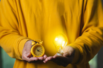 Man holding  light bulbs with clock alarm, concept time manage of good ideas  for working business finance  
investmen.