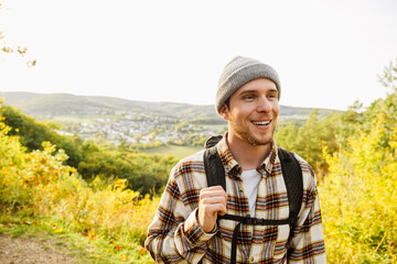 Naklejka na ściany i meble Young joyful man tourist standing at forest glade