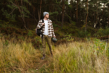 Young active man tourist hiking in beautiful forest
