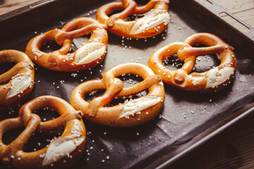 Fresh baked homemade German pretzel with sea salt on baking sheet
