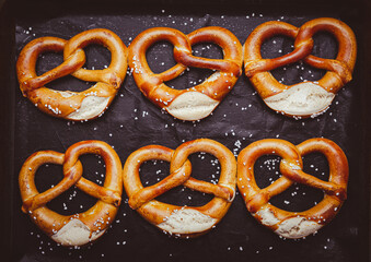 Fresh baked homemade German pretzel with sea salt on baking sheet