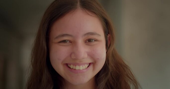 Slow motion scene of a happy smiling and laughing girl who is studying in Asian high school.