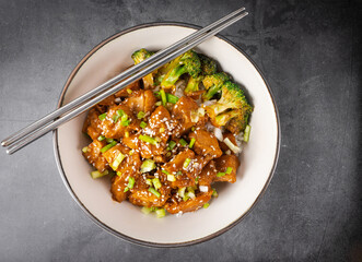 Chopsticks with Delicious sweet chopping chicken rice, sesame seeds, sliced spring onions, broccoli, and vegetables. Asian food, Japanese food. Top view