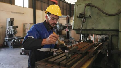 the industry operator uses the brush for cleaning and painting rust preventive oil on the drilling machine. maintenance concept.