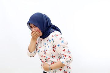 Asian muslim woman standing while holding her stomach and feeling nauseous and going to vomit