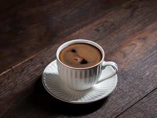 cup of espresso . white cup and saucer on a wooden table
