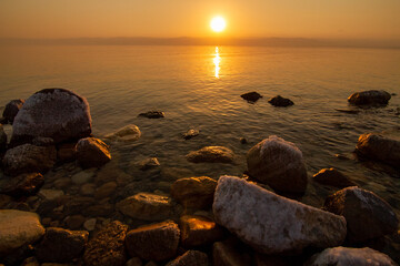 Fototapeta na wymiar Sunset at Dead sea in Jordan, salty rocks 