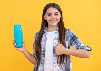 teen girl with shampoo cosmetics isolated on yellow, thumb up. teen girl