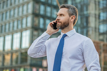 handsome businessman having smartphone call in the street. businessman call on smartphone