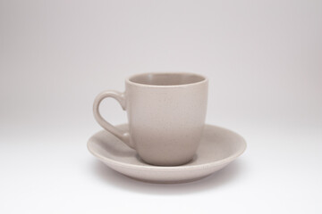 Grey ceramic and saucer on a white background