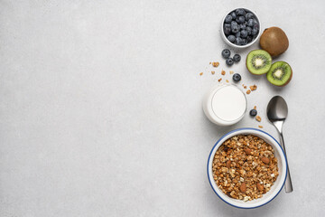 Oatmeal granola, milk, berries and fruits on light background. Ingredients for making homemade breakfast top view