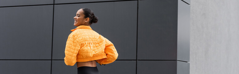 cheerful african american sportswoman in yellow puffer jacket exercising outside, banner. © LIGHTFIELD STUDIOS