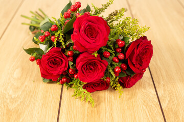 Closeup red roses lying on wooden background. 