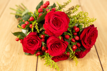Closeup red roses lying on wooden background. 