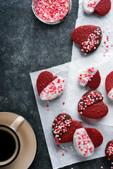 Red velvet or brownie cookies on heart shaped in chocolate icing with red roses on black background. Dessert idea for Valentines Day, Mothers or Womens Day. Homemade dessert. Cake for Valentines Day.