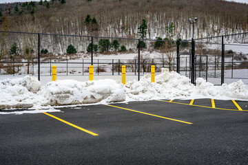 4 Large Yellow Concrete Pillars are placed on the edge of the parking lot to protect the Tennis...
