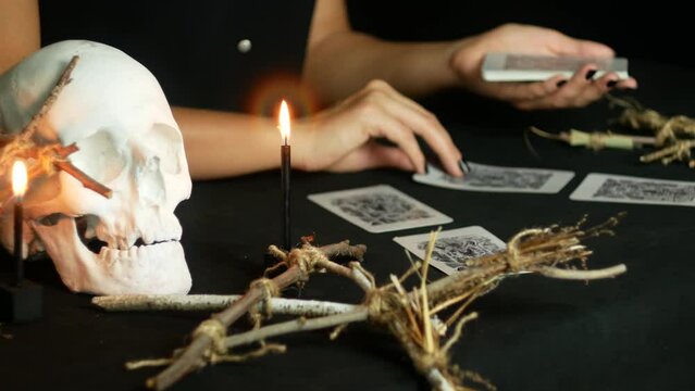 Fortune telling on the dark tarot, holding a seance of spiritualism. Burning red and black candles. An ominous situation in the frame.