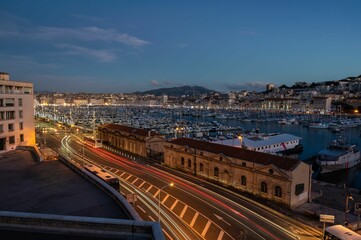 Naklejka na ściany i meble Marseille, Provence, France - View over the old port and the Major Avenue at dusk with colorful lights and ships