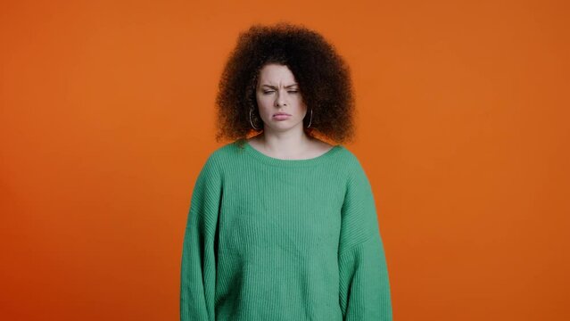 Furious angry brunette gesturing with hands, asking what at camera against a color orange background