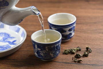 White Ceramic Chinese style Teapot pouring Chinese tea in Ceramic cup. White Ceramic Chinese style Teapot set for tea break time.