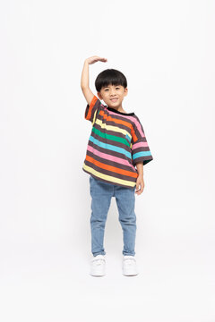 Happy Asian little boy pose to measure your own height, Looking at camera and full body composition