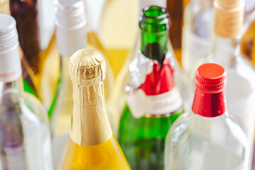 Full and empty bottles of different alcoholic drinks, abuse and alcohol addiction