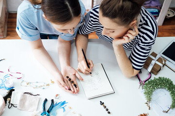 Money making crafts do at home, how to make money crafting. Small local business. Two Female jewelry artists making jewelry. Two business owner women designing jewelry in workshop, studio